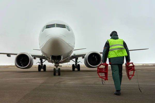 Ground crew meets passenger airplane. Plane in parking.