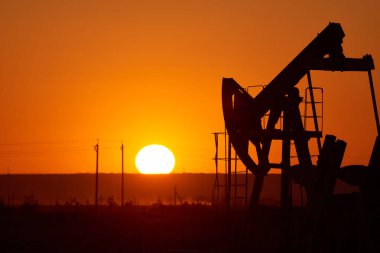 Günbatımı arka planında yağ pompası. Dünya Petrol Endüstrisi. Kazakistan 'ın batı bölgesi