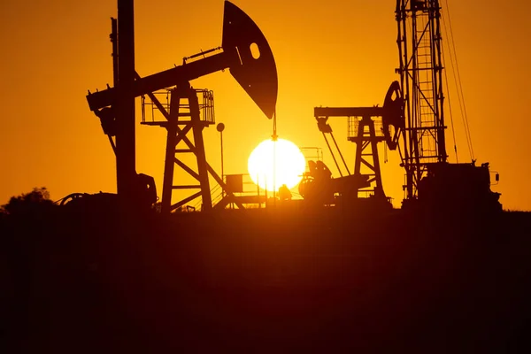 Oil pump oil rig energy industrial machine for petroleum in the sunset background for design. World Oil Industry. Western region of Kazakhstan.