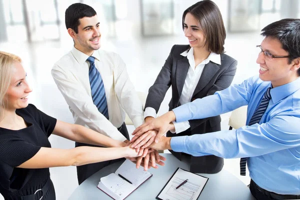 Equipo de negocios poniendo sus manos en la cima — Foto de Stock