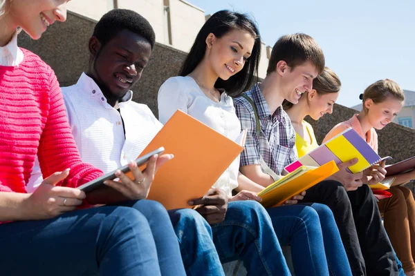 Group of university students studying reviewing homework