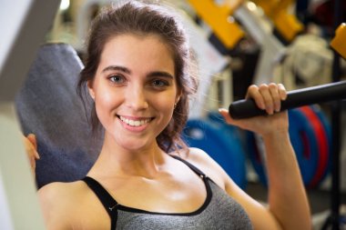 Kadın kol egzersizleri yapıyor spor salonunda 