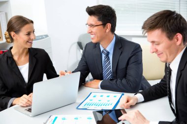 Ofiste dizüstü bilgisayarla çalışan iş adamları