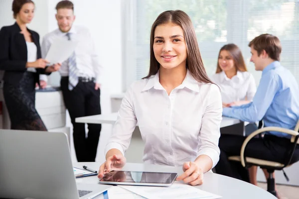 Beautiful young businesswoman with colleagues — Stock Photo, Image