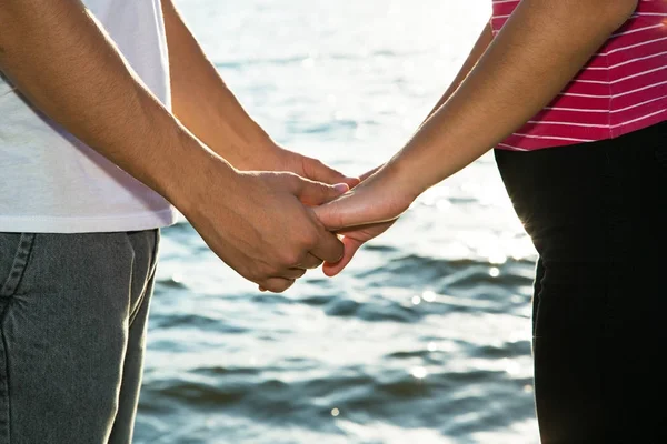 Paar bedrijf handen op de zee. — Stockfoto