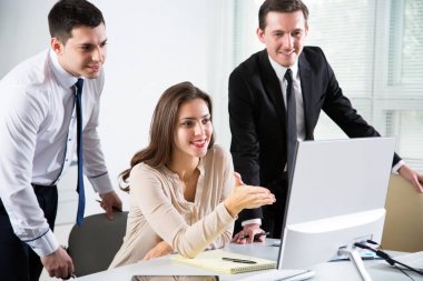 Ofiste bilgisayarla çalışan bir grup iş adamı.