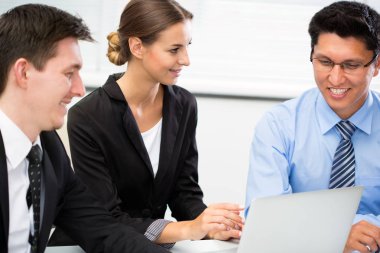 Ofiste dizüstü bilgisayarla çalışan iş adamları