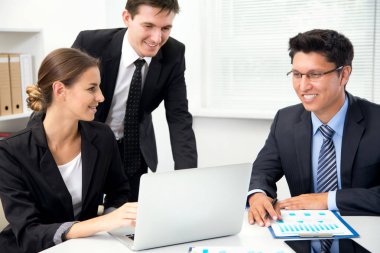 Ofiste toplanan bir grup mutlu iş adamı.