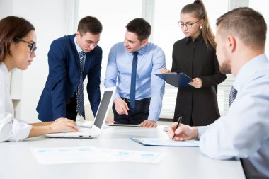 Grup iş adamları modern ofisindeki bir masa etrafında bir toplantıda