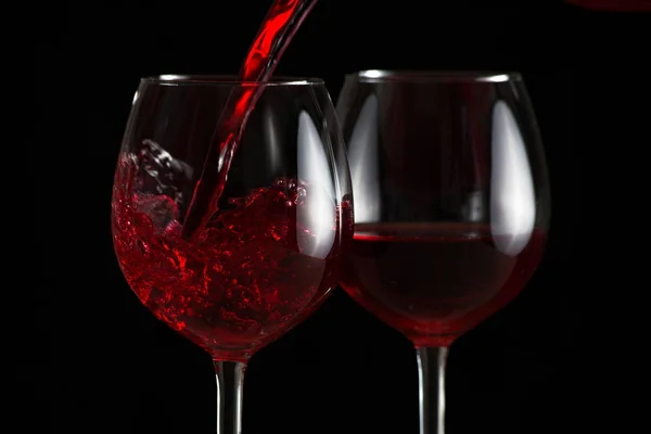 Splash of red wine in a glasses — стоковое фото