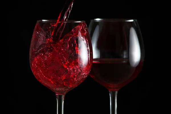 Splash of red wine in a glasses — стоковое фото