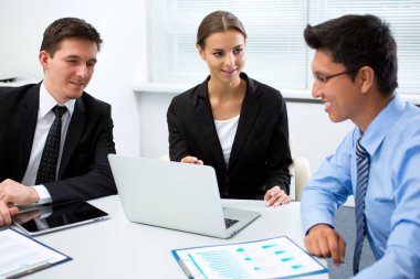 Ofiste dizüstü bilgisayarla çalışan iş adamları