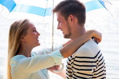 Genç bir çift sahilde yürüyor.