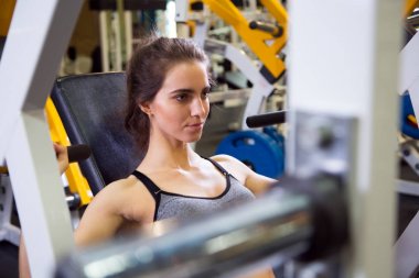 Kadın kol egzersizleri yapıyor spor salonunda 