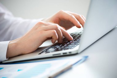 bir dizüstü bilgisayarda yazarak iş adamı.