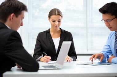 Ofiste dizüstü bilgisayarla çalışan iş adamları