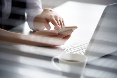 Telefon tutarak ve dizüstü bilgisayar kullanarak iş kadını.