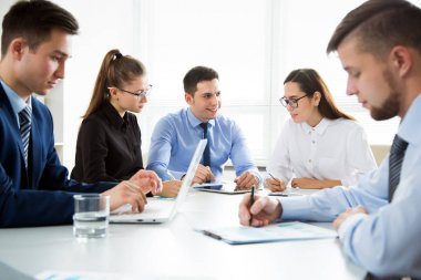 Grup iş adamları modern ofisindeki bir masa etrafında bir toplantıda