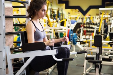 Kadın kol egzersizleri yapıyor spor salonunda 