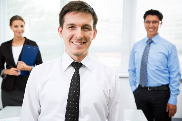 Young businessman with colleagues in the background