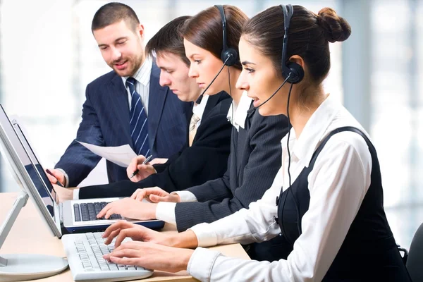 Team of people working with headsets on in a call center