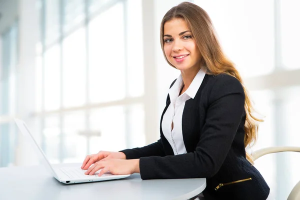 Empresária usando laptop no escritório — Fotografia de Stock