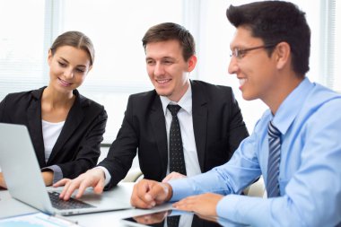 Ofiste dizüstü bilgisayarla çalışan iş adamları