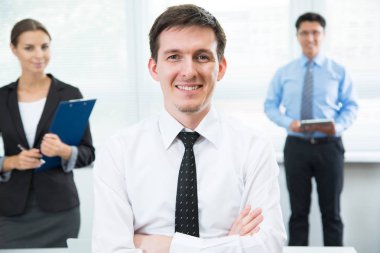 Arka planda ekibi ile mutlu işadamı