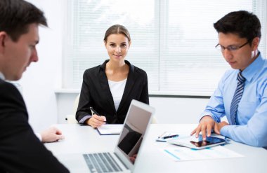 Ofiste dizüstü bilgisayarla çalışan iş adamları