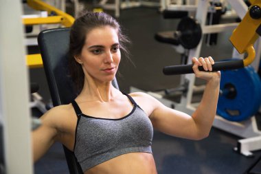 Kadın kol egzersizleri yapıyor spor salonunda 