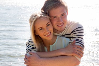 Genç bir çift sahilde yürüyor.