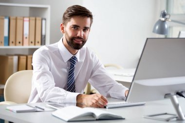 Ofiste bilgisayarla çalışan bir iş adamı