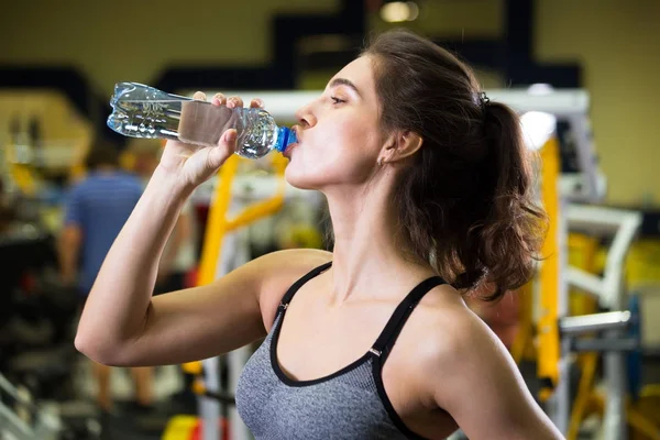 Fitness-Frau trinkt Wasser aus Flasche. — Stockfoto