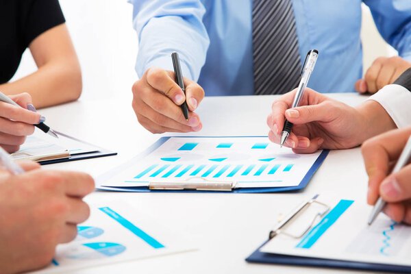 Close-up of businessman explaining a financial plan to colleagues at meeting