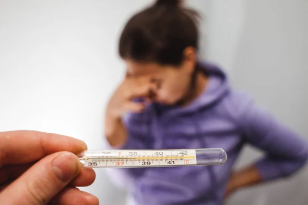 Thermometer met een hoge temperatuur. Het meisje is overstuur. Hoge koorts is een van de symptomen van het coronovirus — Stockfoto