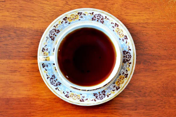 Xícara de chá preto na mesa de madeira, vista superior — Fotografia de Stock