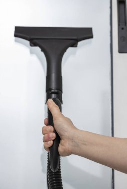 Covid-19 'u önlemek için cam temizleme ve dezenfekte etmek için buhar tabancasıyla el. Salgın, salgın koronavirüs, grip salgını. ...