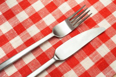 Çatal ve kaşık damalı bir masa örtüsü.