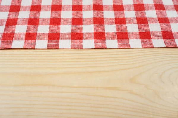 Red and white tablecloth on white wooden table. Selective focus, copy space