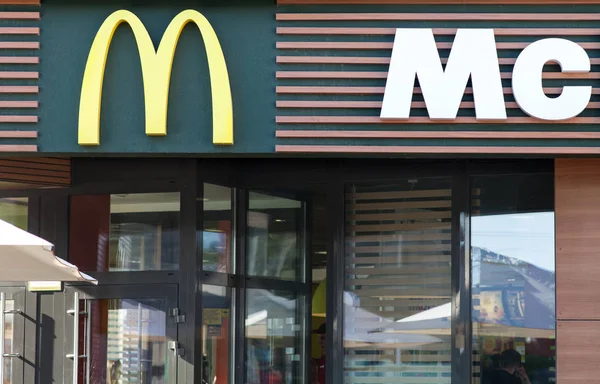 Minsk, Wit-Rusland - 6 juni 2017: het logo van de Mcdonald's boven de ingang van het restaurant. McDonald's is's werelds grootste keten van hamburger fast-food restaurants — Stockfoto