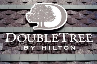 Minsk, Beyaz Rusya - 17 Haziran 2017: otel Hilton otel Minsk tarafından çift ağaç Binası cephe üzerinde Logo
