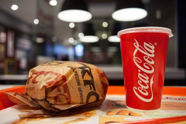 Minsk, Belarus, 27 Mart 2018: Kfc logo ve aper Kupası Coca Cola logosu tablo Kfc restoranı ile sandviçle
