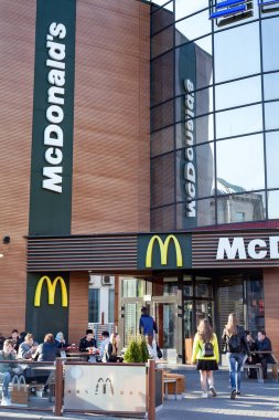 Minsk, Beyaz Rusya, 20 Nisan 2018: Mcdonald's ın Minsk. Masada oturan ve açık havada yemek sokakta insanlar