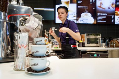 Minsk, Beyaz Rusya, 24 Nisan 2018: Kompozisyon bardak ve kahve çekirdekleri bir Mccafe Mcdonald's restoranında kahve yapma bir barmen arka plan üzerinde