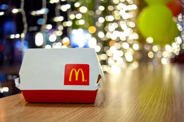 Minsk, Belarus - 22 Kasım 2019: McDonald 's Restoran' daki Noel çelenklerinin arka planında McDonald 'ın logosu olan Big Mac Box