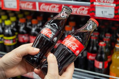 Minsk, Belarus - 13 Aralık 2019: bir elde iki Coca-Cola şişesi. Alıcı hangi içeceği şekersiz ya da şekersiz alacağını seçer. Beslenme seçimi konsepti.
