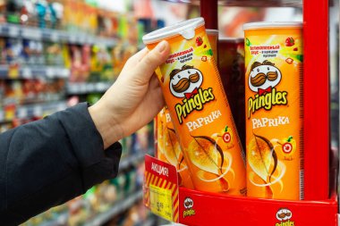 Minsk, Belarus - 19 Aralık 2019: bir alıcı süpermarketten Pringles cipsi alır. Yeni bir paket Pringles patates cipsi..