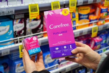 Minsk, Belarus - 2 Şubat 2020: Bir kadın ne tür hijyenik peçete alacağını seçer. Hijyenik peçeteler. Ellerinde farklı tipler var..