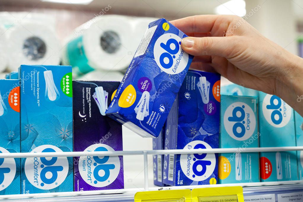 MINSK, BELARUS - February 2, 2020: Woman buys Tampons O.B. in a supermarket.