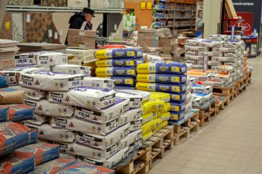 MINSK, BELARUS - 22 Mart 2020: İnşaat malzemeleri bir hırdavatçıda satılıyor. İnşaat ve onarım için torbalar dolusu çimento, sıva ve diğer malzemeler paletlerin üzerine istiflenmiş..